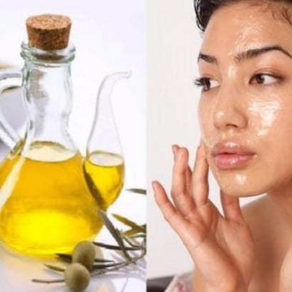 Woman applying oil to her face